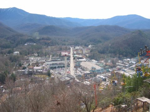 1985 Ford LTD Crown Victoria - A view of Gatlinburg, Tennessee, showing the main street, ski lift, and surrounding mountains.
