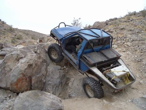1989 Ford Bronco - This heavily modified buggy navigates a challenging rocky obstacle during an off-road excursion.