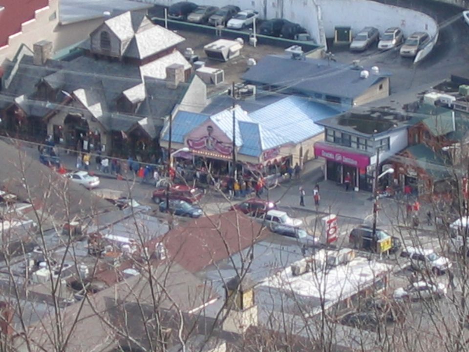 Street scene with parked cars and buildings, including a pink-fronted shop