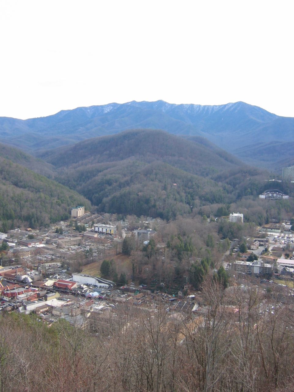 Overhead view of a town in a valley with mountains in the background