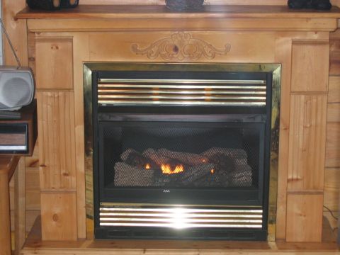 1985 Ford LTD Crown Victoria - Interior view of a gas fireplace with a wooden surround and decorative trim.