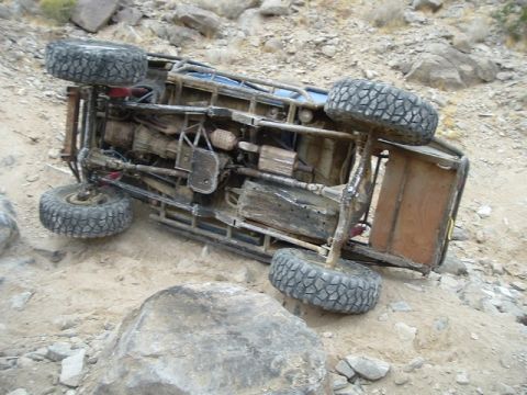 1989 Ford Bronco - This off-road vehicle has rolled onto its side in a rocky, desert environment.