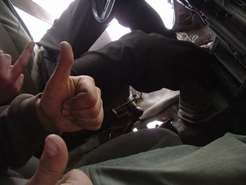 1989 Ford Bronco - Two people inside a vehicle giving thumbs up, with the steering wheel and dashboard in view.