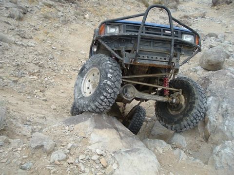 1989 Ford Bronco - This modified Toyota truck is navigating a rocky trail, demonstrating its off-road capabilities.
