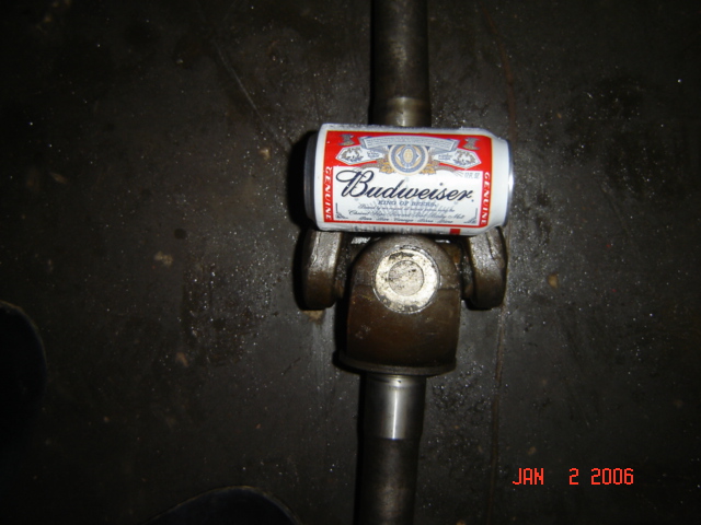 Driveshaft universal joint with a Budweiser can on top. Date stamp reads JAN 2 2006