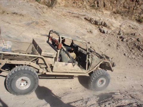 1989 Ford Bronco - This off-road buggy navigates a steep, dusty incline in a desert landscape.