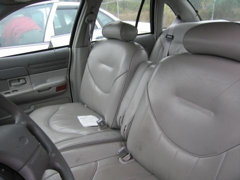 1991 Ford Crown Victoria LTD - The interior of a car shows light gray leather seats and door panels, with another vehicle visible outside.