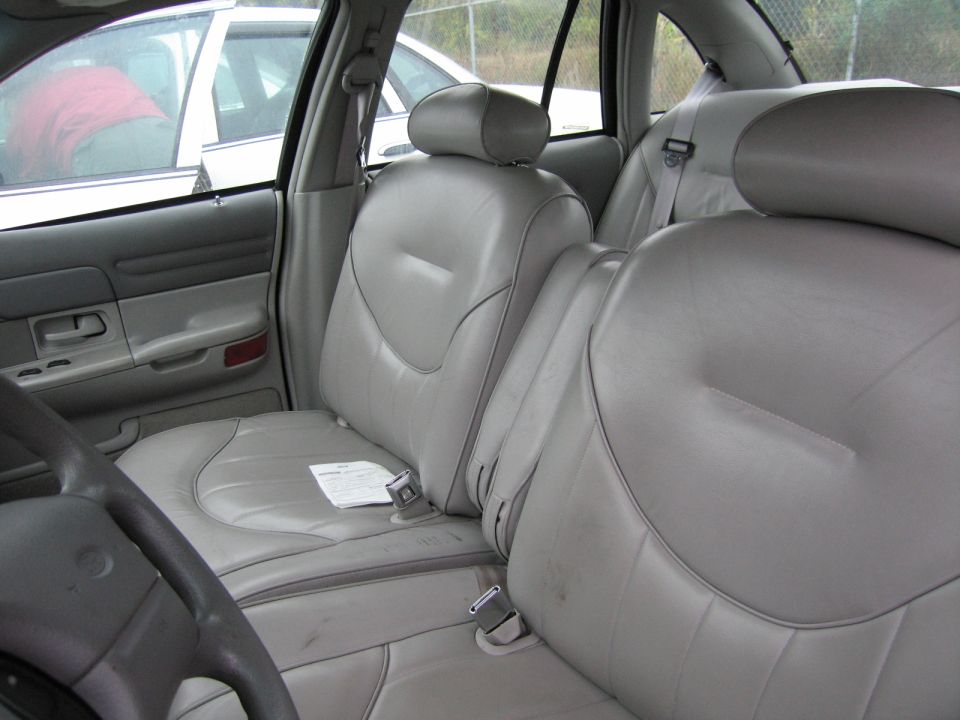 Interior shot of a car showing front and back seats, with another car visible through the window