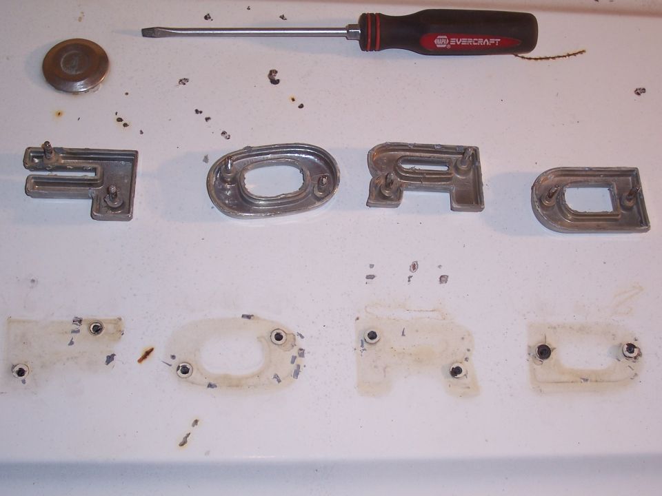 The letters can be removed by prying either side of the letter with a small flathead screwdriver. Notice the prongs and the holes that they go into.