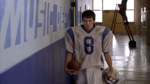 1993 Ford Taurus - A young athlete walks down a school hallway, carrying his football gear.
