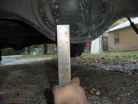 1989 Ford Bronco - A ruler is used to measure the clearance of a vehicle's rear axle.