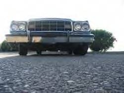 1972 Ford Ranchero - The front of a 1977 Ford Ranchero is captured from a low angle, showing its grille and headlights.