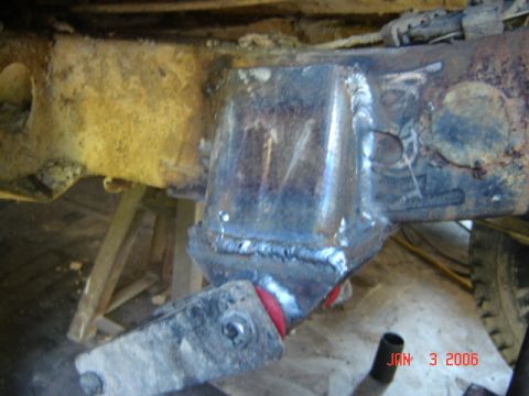 1982 Nissan Titan - Close-up of a welded suspension component on a heavily rusted vehicle frame.