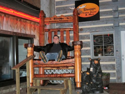 1985 Ford LTD Crown Victoria - A man enjoys a photo opportunity in a massive wooden rocking chair outside a shop in Gatlinburg, Tennessee.