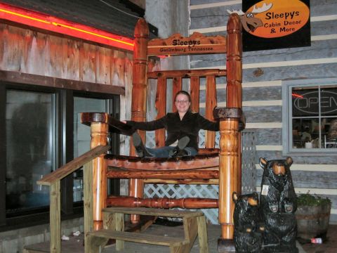 1985 Ford LTD Crown Victoria - Giant wooden chair at Sleepy's in Gatlinburg, Tennessee, with a person posing for a photo. Bear carvings are visible.