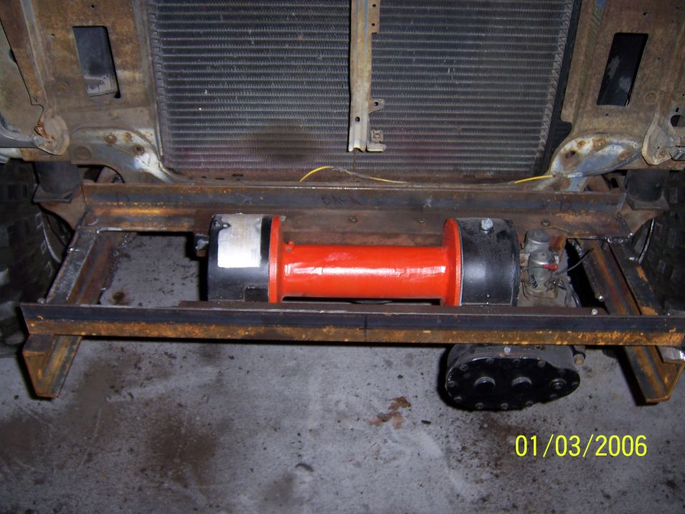 Orange winch mounted in front frame crossmember behind radiator, dated 01/03/2006