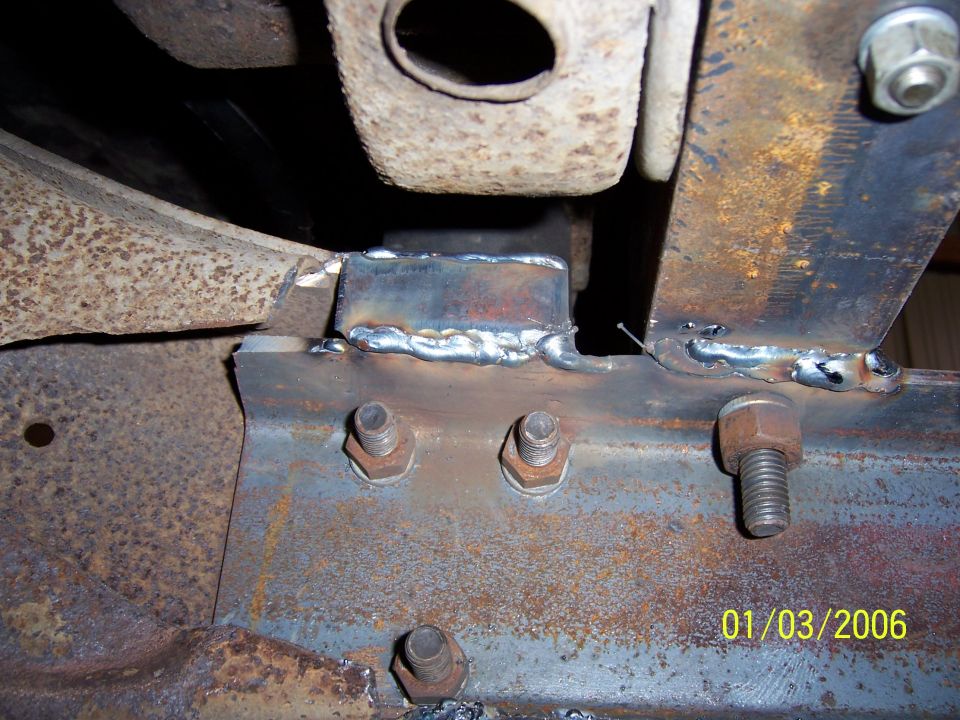 Welded reinforcement plate over bolted bracket on a rusty truck frame rail, dated 01/03/2006
