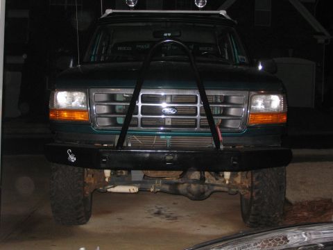 1996 Ford Bronco - Front view of a green Ford Bronco with a custom bumper and roof-mounted lights.