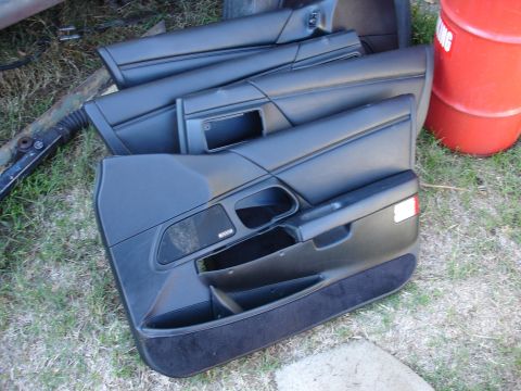 1993 Ford Taurus - Stacked car door panels, likely for interior swap, are shown outdoors on the grass.