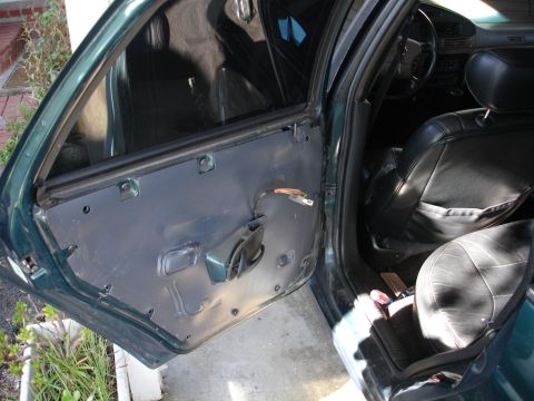 1993 Ford Taurus - The interior of a car is shown with the driver's side door panel removed, revealing the inner workings.
