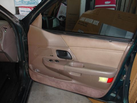 1993 Ford Taurus - Interior door panel of a 1993 Ford Taurus, tan upholstery and dark green trim.