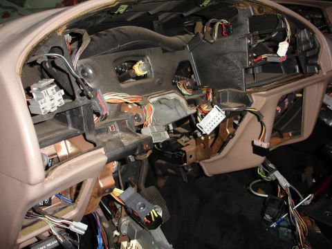 1993 Ford Taurus - The interior of a car is shown with the dashboard disassembled and wiring exposed.