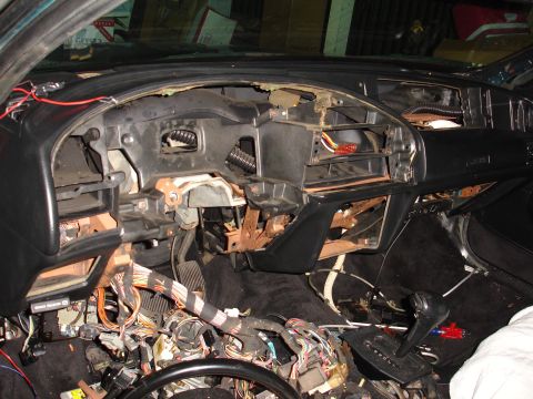 1993 Ford Taurus - The interior of a car is disassembled, revealing exposed wiring and components beneath the dashboard.