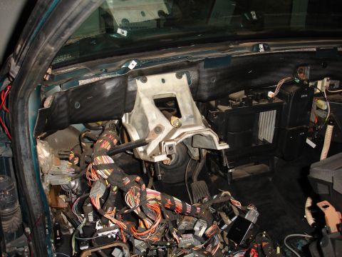 1993 Ford Taurus - The interior of a vehicle shows a disassembled dashboard with extensive exposed wiring and various electronic components.