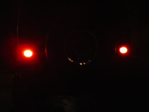 1989 Jeep YJ - A dark image shows the rear of a vehicle with illuminated taillights and a spare tire mount.