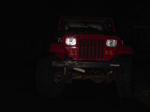 1989 Jeep YJ - Front view of a red 1989 Jeep YJ, identified by its distinctive body style and grille, fitted with an aftermarket bumper.