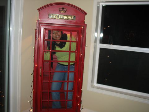 1997 Ford Probe - A woman stands inside a red telephone booth, which is decorated with string lights.
