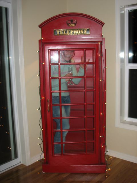 1997 Ford Probe - A person stands inside a red telephone booth, holding a glass and waving.