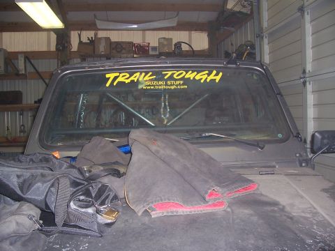 1988 Suzuki Samurai - Interior view of a 1988 Suzuki Samurai, modified with a roll cage and "Trail Tough" decal.