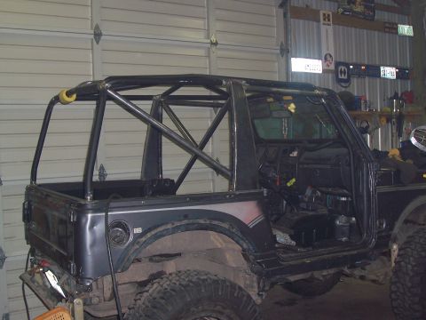 1988 Suzuki Samurai - This Suzuki Samurai is undergoing modifications with a prominent roll cage structure.