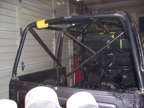 1988 Suzuki Samurai - The interior of an off-road vehicle is shown, a custom-built roll cage and a partially visible dashboard.