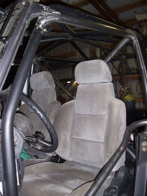1988 Suzuki Samurai - Vehicle interior showing front seats and extensive roll cage tubing.