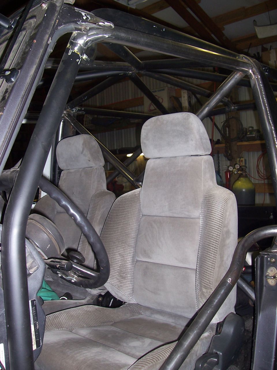 Interior view of a vehicle's front seats and roll cage structure
