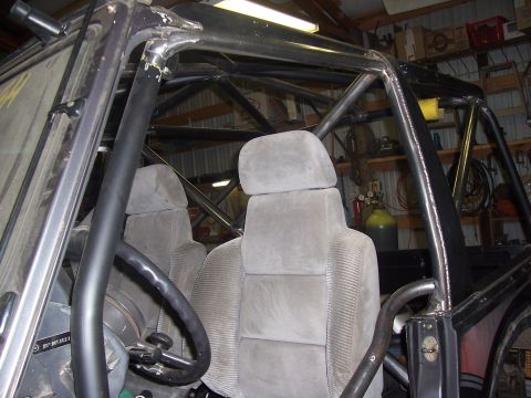 1988 Suzuki Samurai - Custom roll cage installed inside a vehicle with fabric bucket seats and a steering wheel.