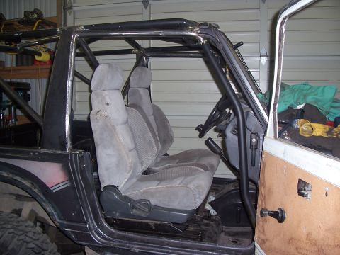 1988 Suzuki Samurai - Interior view of a 1988 Suzuki Samurai showing its gray seats and custom roll cage.