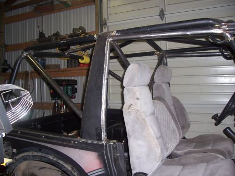 1988 Suzuki Samurai - Interior view of a vehicle with a custom roll cage and fabric seats, suggesting off-road modifications.