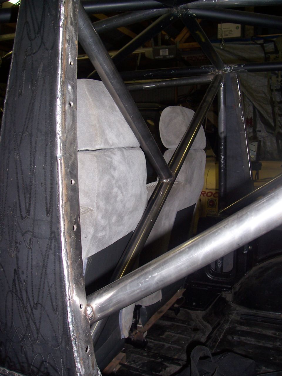 Vehicle interior with custom roll cage, grey seats, and black floor