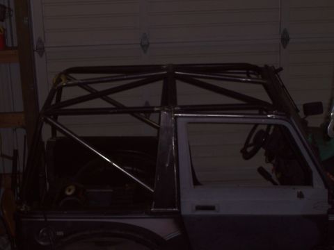 1988 Suzuki Samurai - A vehicle is shown with a custom roll cage, obscuring some of its original features.