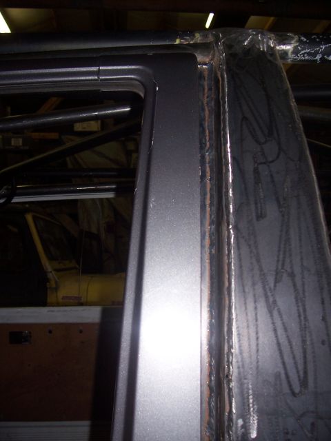 1988 Suzuki Samurai - Custom roll cage tubing is welded into the door frame of a vehicle's interior.