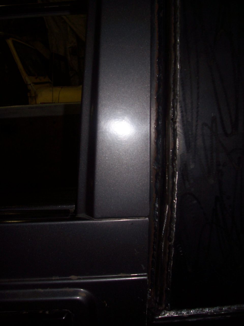 close-up of a dark gray vehicle's door frame and edge
