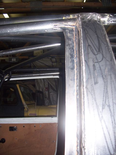 1988 Suzuki Samurai - The interior of a vehicle shows extensive roll cage modifications and a partial view of another vehicle.