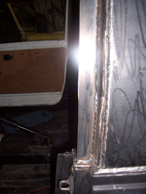 1988 Suzuki Samurai - Close-up view of a welded metal frame and a vehicle door, possibly undergoing modification.