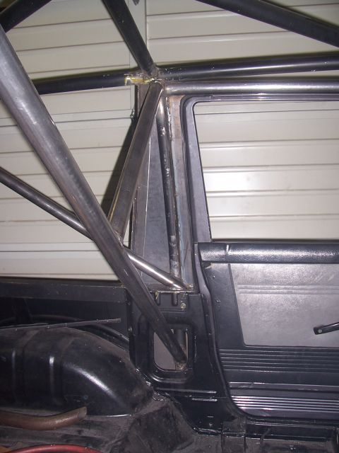 1988 Suzuki Samurai - Close-up view of a custom roll cage installed inside a vehicle's interior.