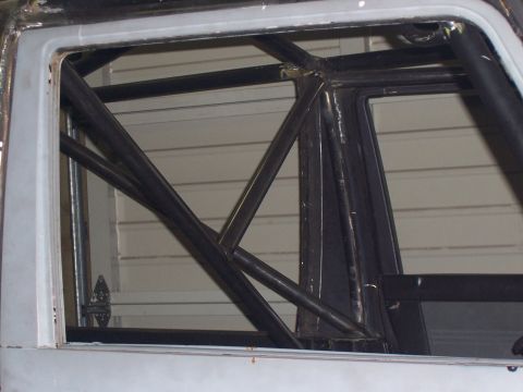 1988 Suzuki Samurai - Close-up of a custom roll cage installed inside a vehicle's cabin.