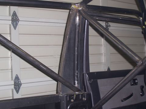 1988 Suzuki Samurai - The interior of a vehicle features a custom-welded roll cage, indicating modifications for off-road use or safety.