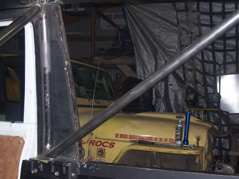 1988 Suzuki Samurai - A yellow off-road vehicle with a prominent roll cage is partially visible in a garage setting.